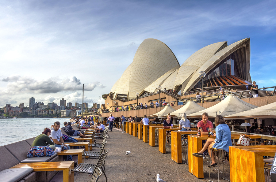 Tourists Sitting In Opera Bar In Front Of Sydney Opera House
