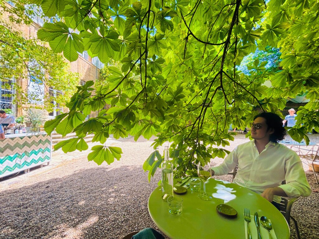オテル・ド・ガリフェの庭のカフェ。大きな木の下の緑のテーブル