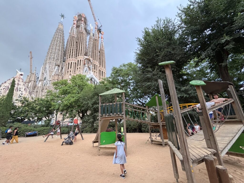 サグラダ・ファミリアの前の公園の遊具と、遊具に向かう娘